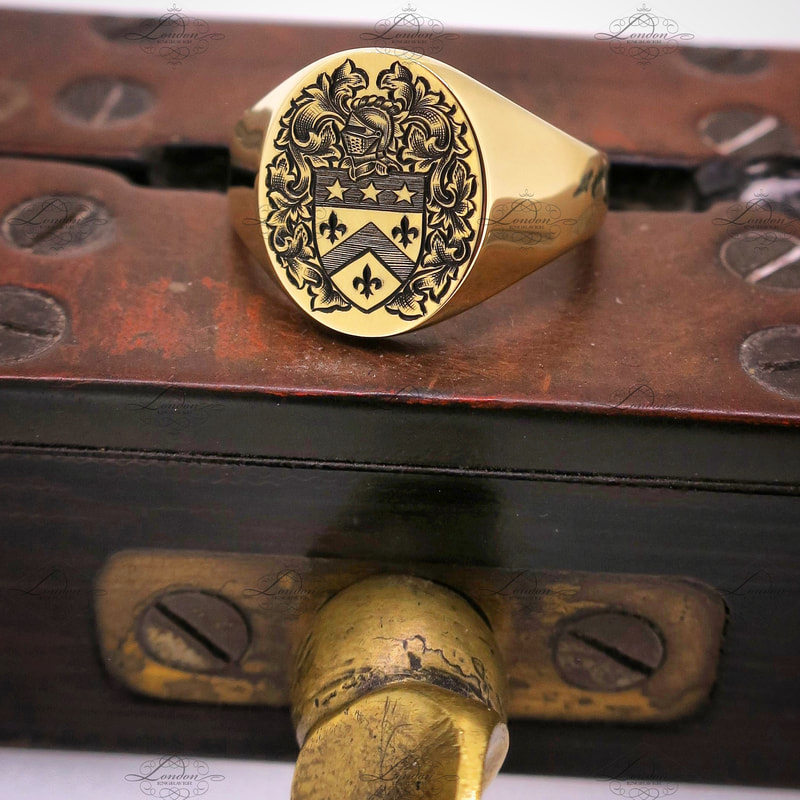 Yellow gold Oxford Oval signet ring with a surface engraved Coat of Arms, finished with black enamel