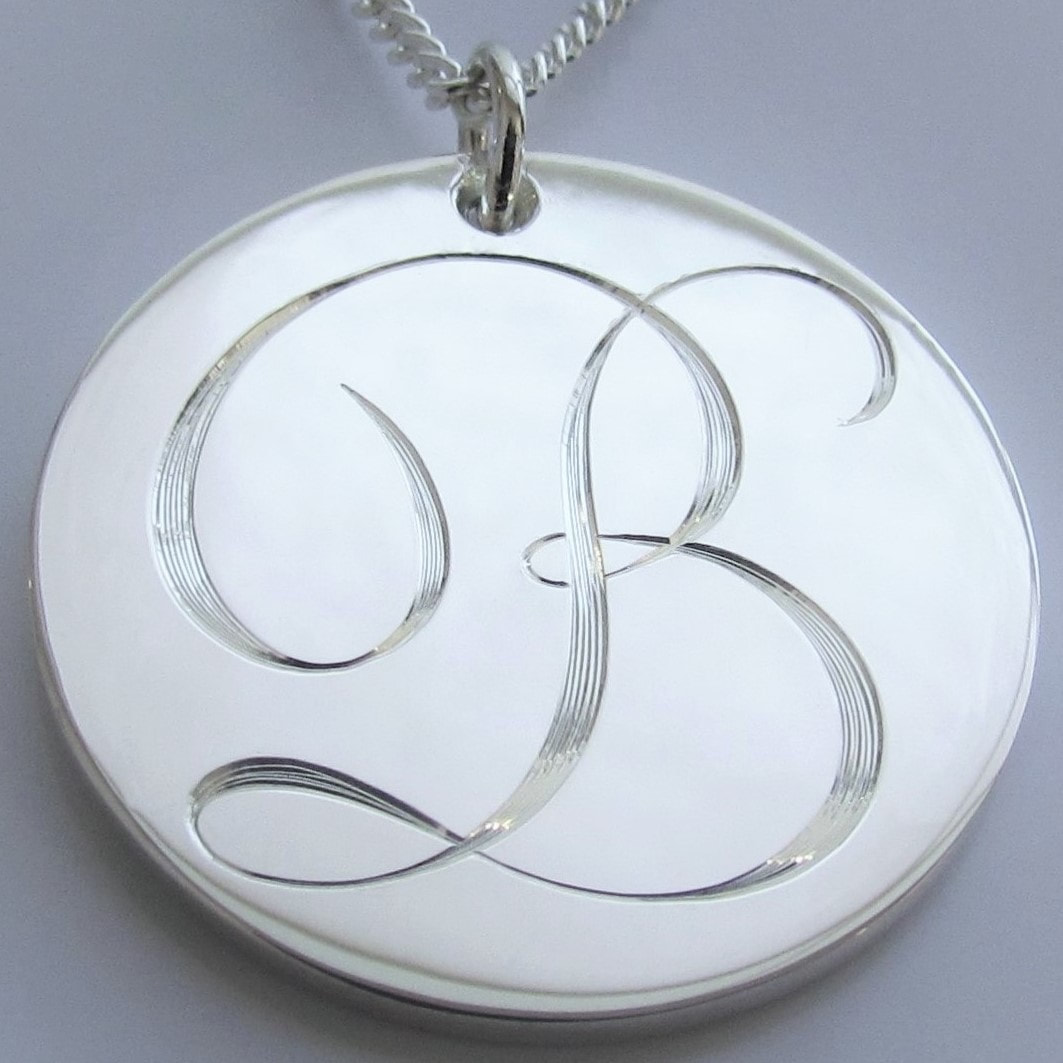 Round sterling silver pendant with a hand engraved script initial B